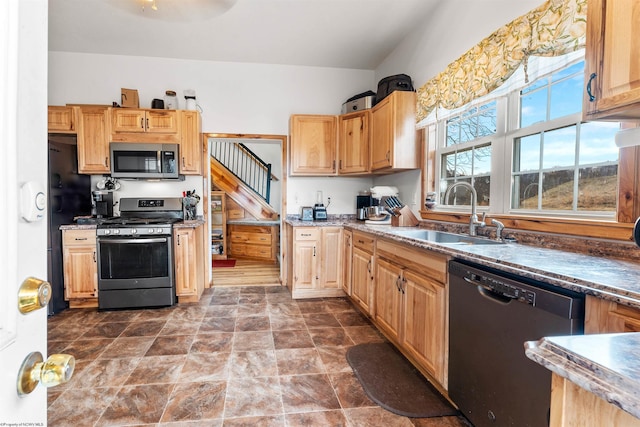 kitchen featuring appliances with stainless steel finishes, stone finish flooring, and a sink