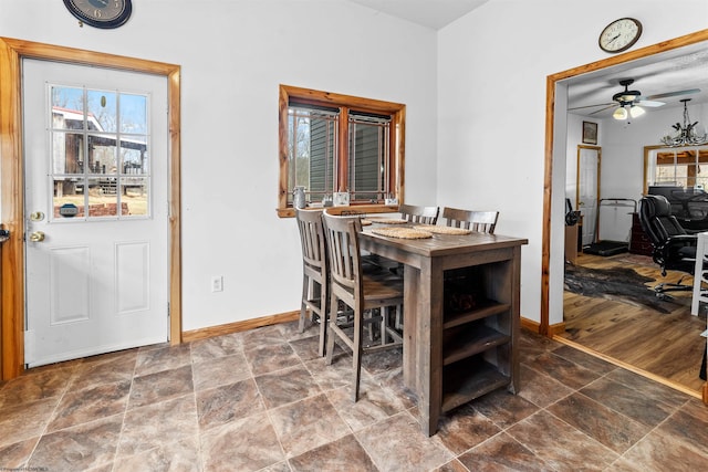 dining room featuring stone finish floor, baseboards, and ceiling fan