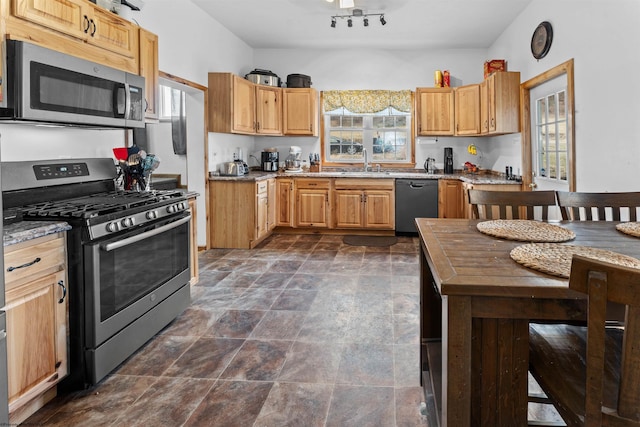 kitchen featuring a sink, stone finish flooring, light stone countertops, and appliances with stainless steel finishes