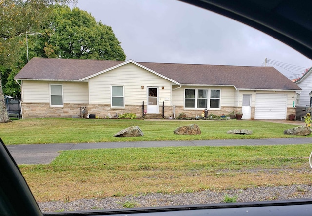 ranch-style home with a front lawn, an attached garage, stone siding, and roof with shingles