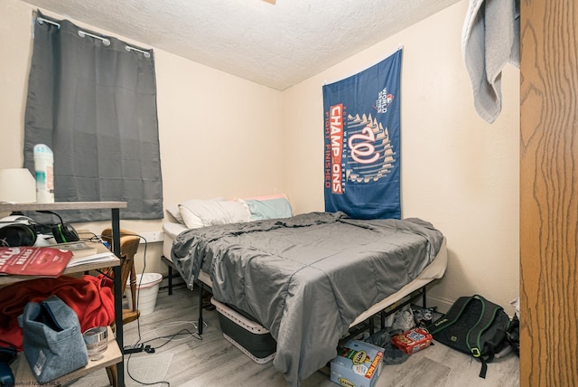 bedroom featuring a textured ceiling and wood finished floors