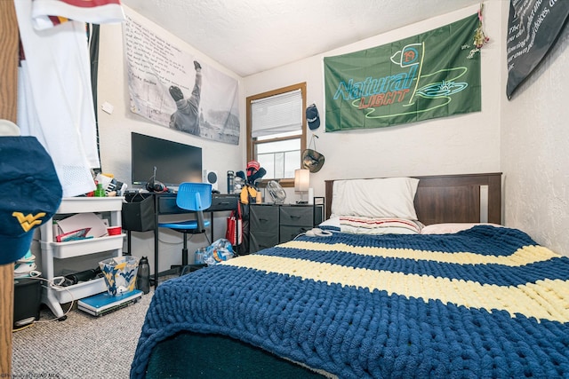 carpeted bedroom featuring a textured ceiling and a textured wall