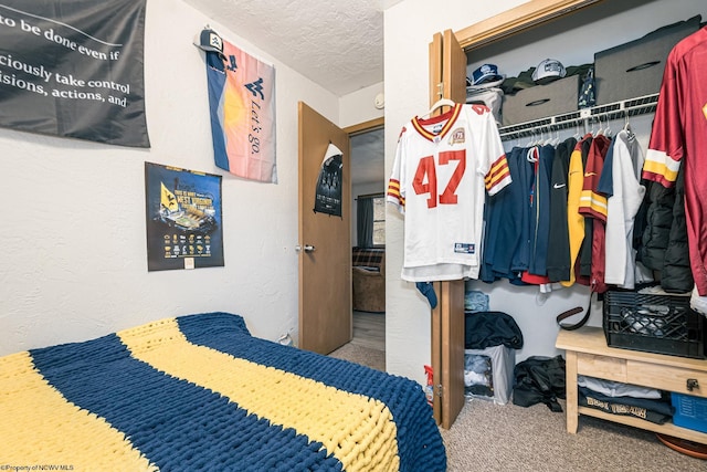 carpeted bedroom featuring a closet, a textured ceiling, and a textured wall