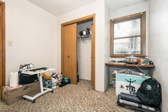 interior space with a closet, a textured ceiling, and a textured wall