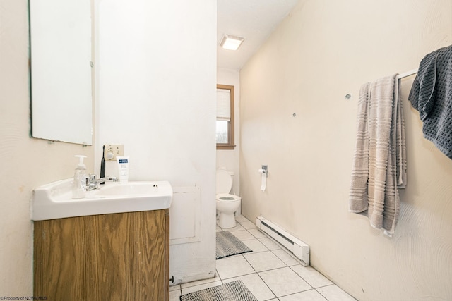 half bathroom featuring tile patterned flooring, toilet, vanity, and a baseboard heating unit