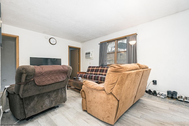 living room with light wood-style flooring and a wall mounted AC