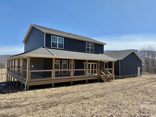 rear view of house with a porch and a shingled roof