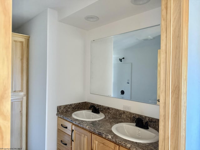 full bathroom with double vanity and a sink