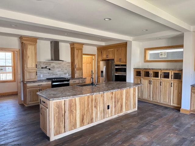 kitchen featuring a sink, tasteful backsplash, dark wood finished floors, stainless steel appliances, and wall chimney exhaust hood