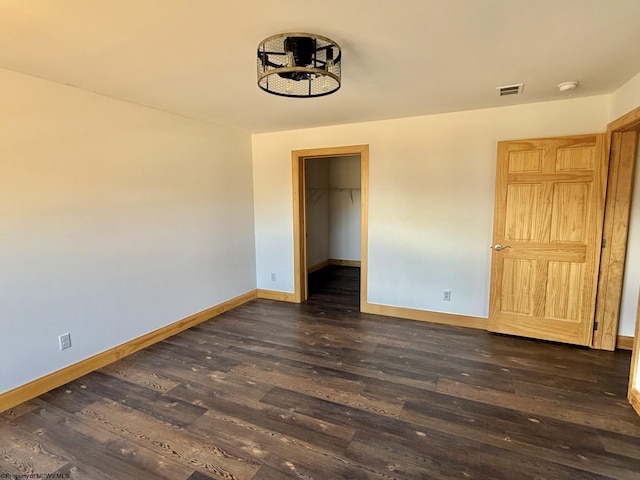 interior space with dark wood-type flooring, baseboards, and visible vents