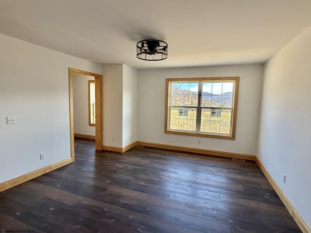 unfurnished room with baseboards and hardwood / wood-style flooring