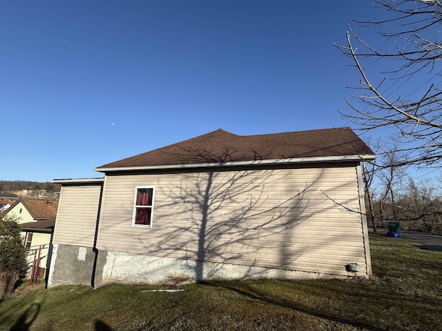 view of property exterior with a yard and a shingled roof