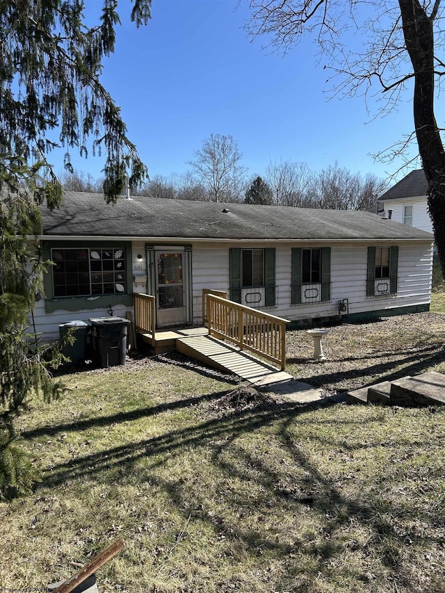 rear view of house with a deck and a yard