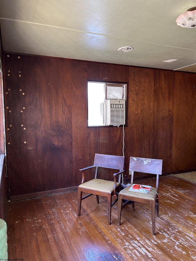 living area with wooden walls and hardwood / wood-style flooring