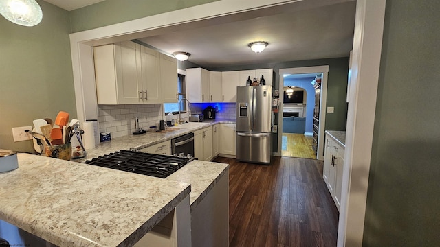 kitchen featuring dark wood-style floors, stainless steel fridge with ice dispenser, a sink, light countertops, and dishwasher