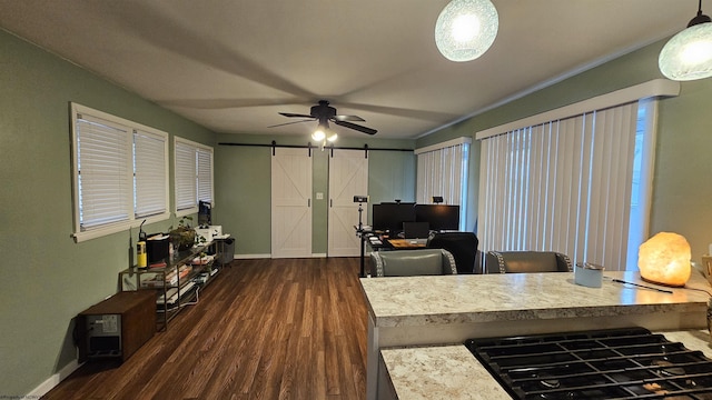 home office with dark wood finished floors, ceiling fan, baseboards, and a barn door