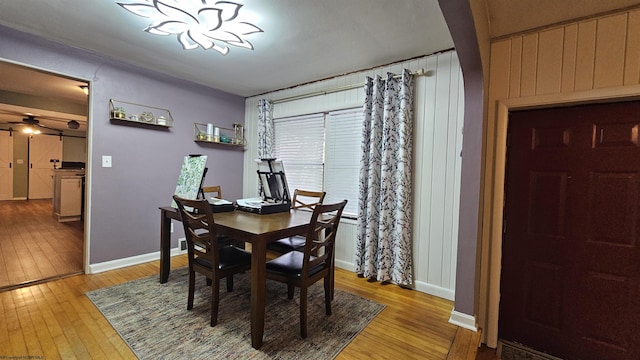 dining space featuring light wood-style flooring, a ceiling fan, and baseboards