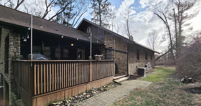 view of side of home with cooling unit and brick siding