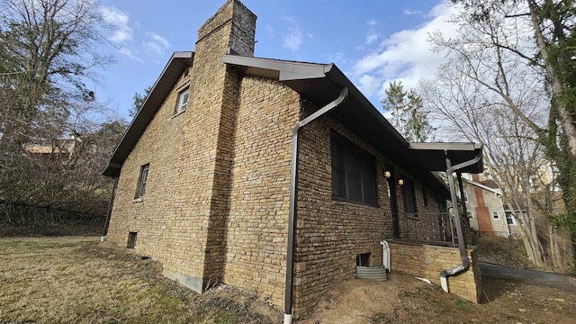 view of side of property featuring brick siding and a chimney