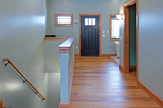 entryway with baseboards and light wood finished floors