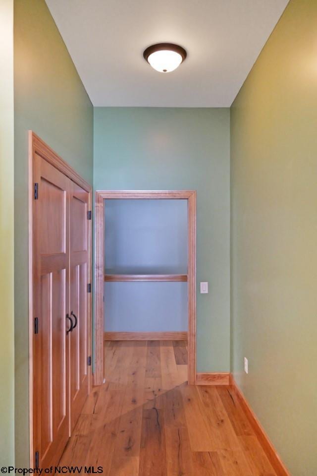 hallway with baseboards and wood-type flooring