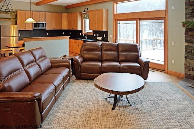 living room featuring beam ceiling, visible vents, and baseboards