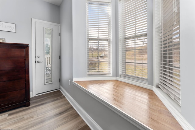 foyer entrance with wood finished floors and baseboards