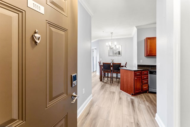 interior space with baseboards, a notable chandelier, crown molding, and light wood finished floors