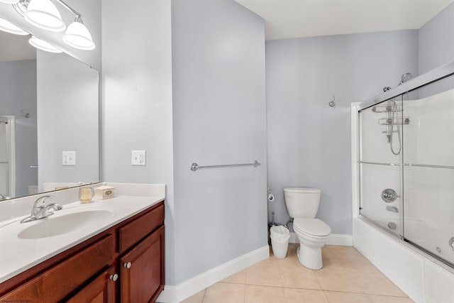 full bathroom with vanity, baseboards, bath / shower combo with glass door, tile patterned flooring, and toilet