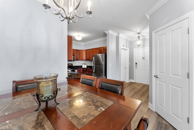 dining space with crown molding, a notable chandelier, baseboards, and light wood finished floors