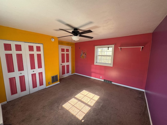 carpeted empty room featuring visible vents, ceiling fan, a textured ceiling, and baseboards
