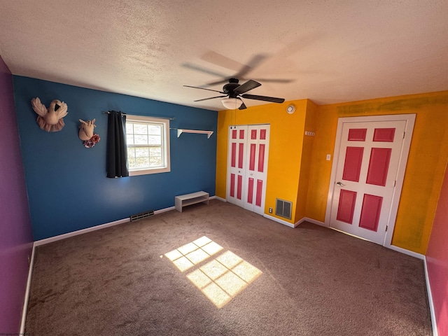 unfurnished bedroom with visible vents, a textured ceiling, ceiling fan, and carpet floors