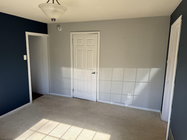 unfurnished bedroom with carpet flooring and baseboards