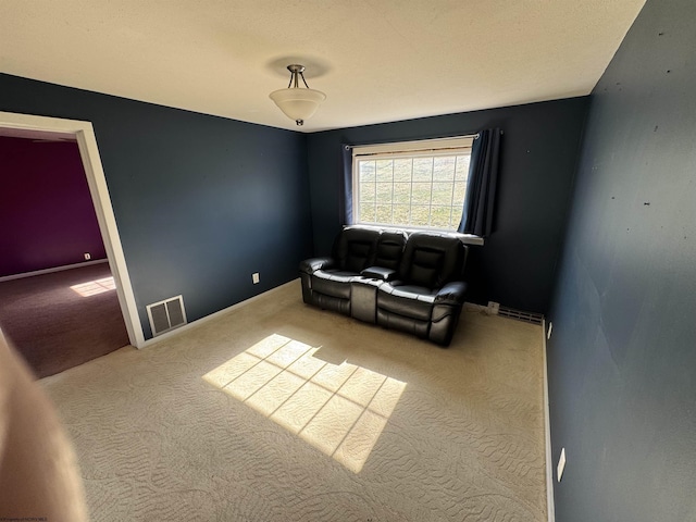 living area featuring visible vents, baseboards, and carpet