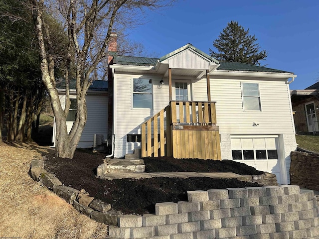 view of front of home featuring metal roof, a chimney, and an attached garage