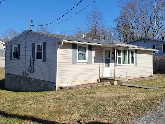 view of front of house featuring a shingled roof and a front yard