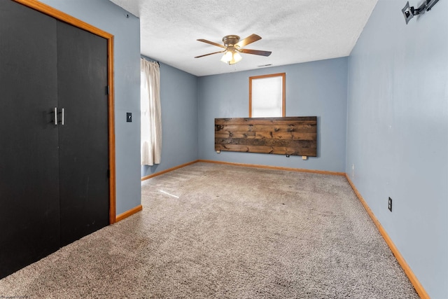 unfurnished bedroom featuring visible vents, baseboards, ceiling fan, a textured ceiling, and carpet flooring