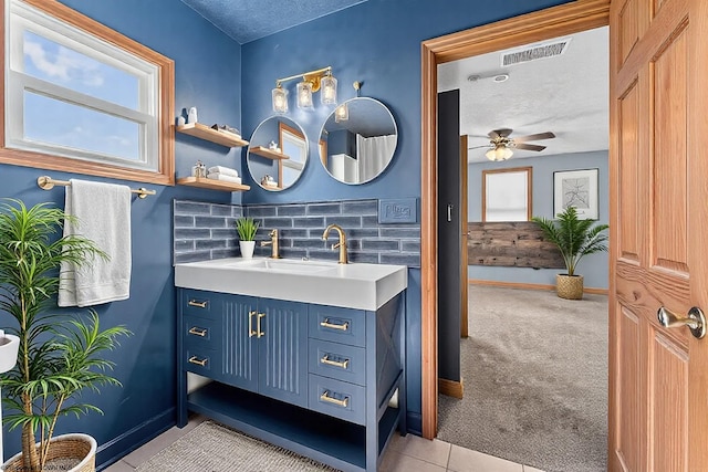 bathroom featuring visible vents, a textured ceiling, baseboards, ceiling fan, and vanity