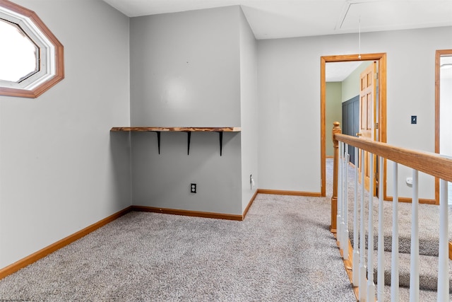 interior space featuring baseboards, attic access, and carpet