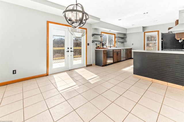 kitchen featuring light tile patterned floors, a sink, light countertops, black refrigerator, and dishwasher