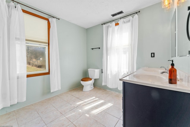 bathroom featuring visible vents, toilet, a sink, tile patterned flooring, and double vanity