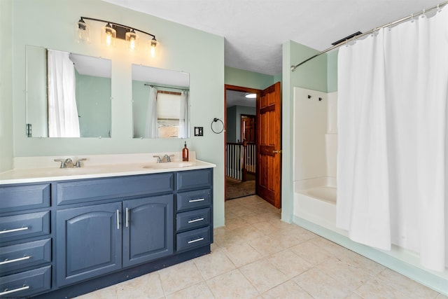 full bathroom featuring tile patterned floors, double vanity, shower / bath combo with shower curtain, and a sink