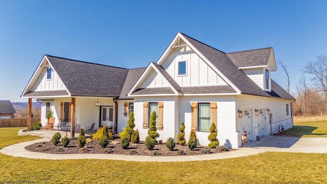 modern inspired farmhouse featuring brick siding, board and batten siding, and a front lawn