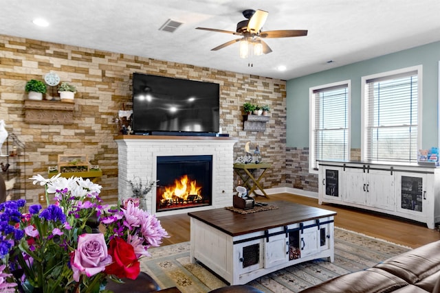 living area featuring visible vents, wood finished floors, recessed lighting, a fireplace, and ceiling fan