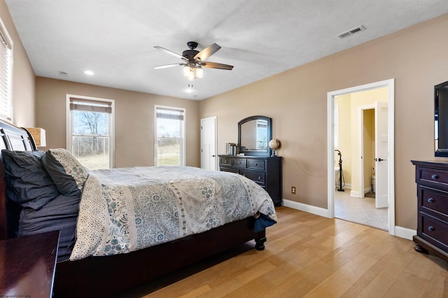 bedroom with visible vents, baseboards, light wood-style floors, and ceiling fan