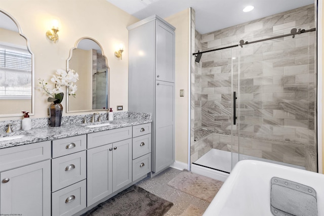 bathroom featuring a sink, a soaking tub, double vanity, and a shower stall