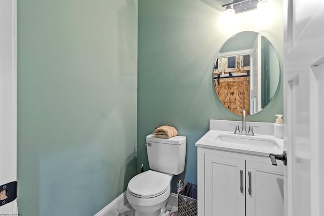 bathroom with toilet, vanity, and baseboards