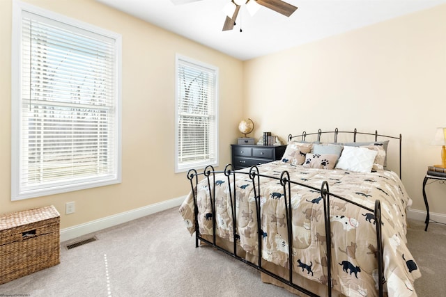 carpeted bedroom featuring visible vents, a ceiling fan, and baseboards