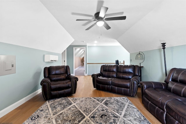 living area featuring baseboards, an AC wall unit, lofted ceiling, wood finished floors, and a ceiling fan