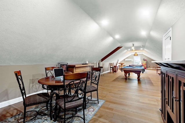 recreation room featuring billiards, baseboards, light wood finished floors, vaulted ceiling, and a textured ceiling